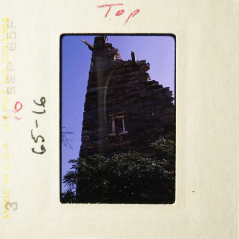 A photo of an old, weathered building with a blue sky background.