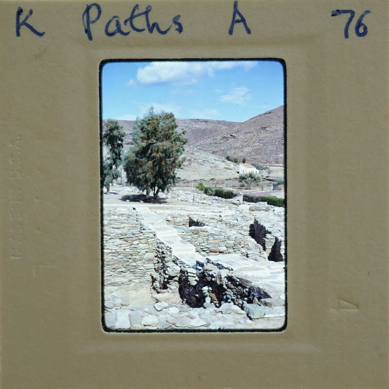 A photograph of a stone ruins with trees and mountains in the background, taken through an old-fashioned film strip viewer.