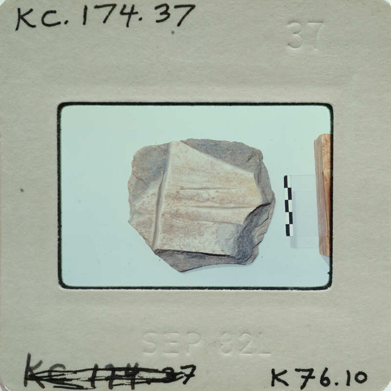 A photograph of a small, weathered stone artifact with markings on it.