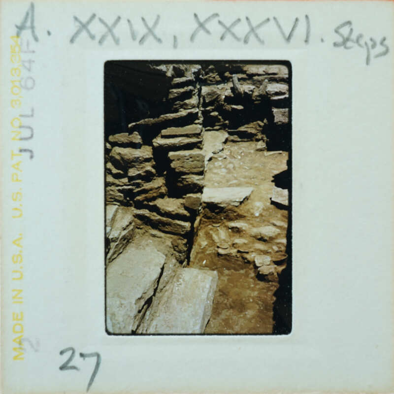 A photograph of a stone wall with visible mortar and cracks, possibly from an old building or ruins.