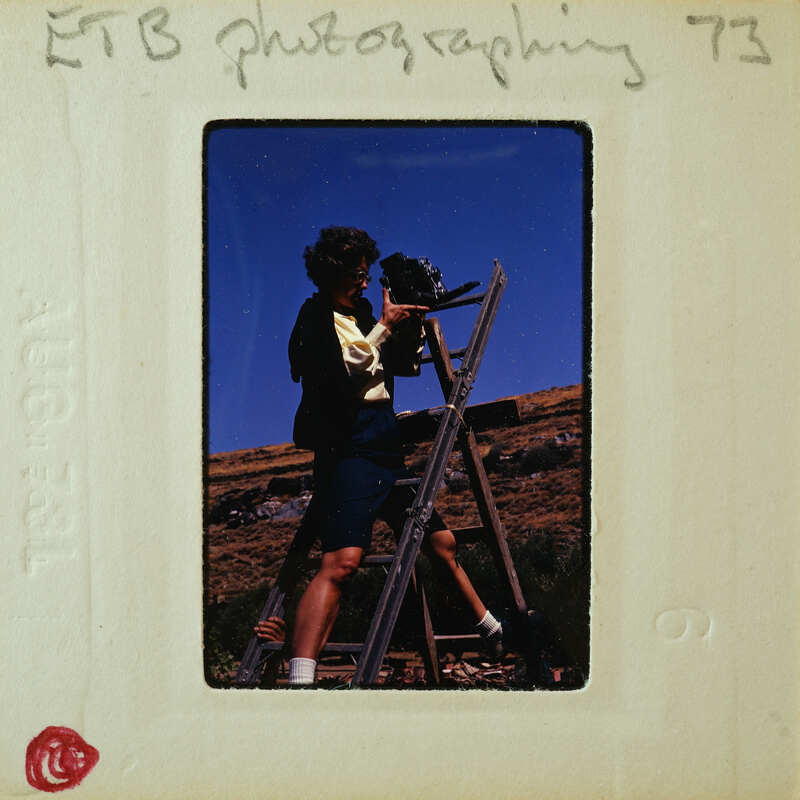 Photographer with camera and tripod on a mountain.