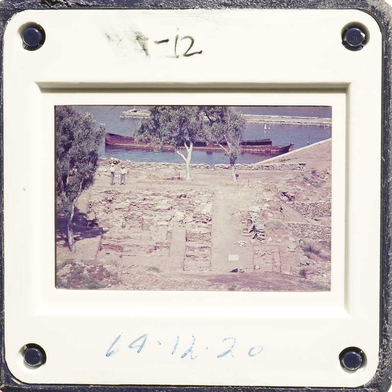 A photograph showing an excavation site with ruins and trees, possibly from an archaeological dig.