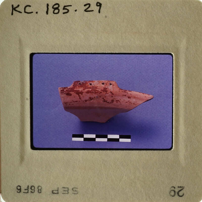 Ancient artifact, possibly pottery, with red markings displayed on a blue background.