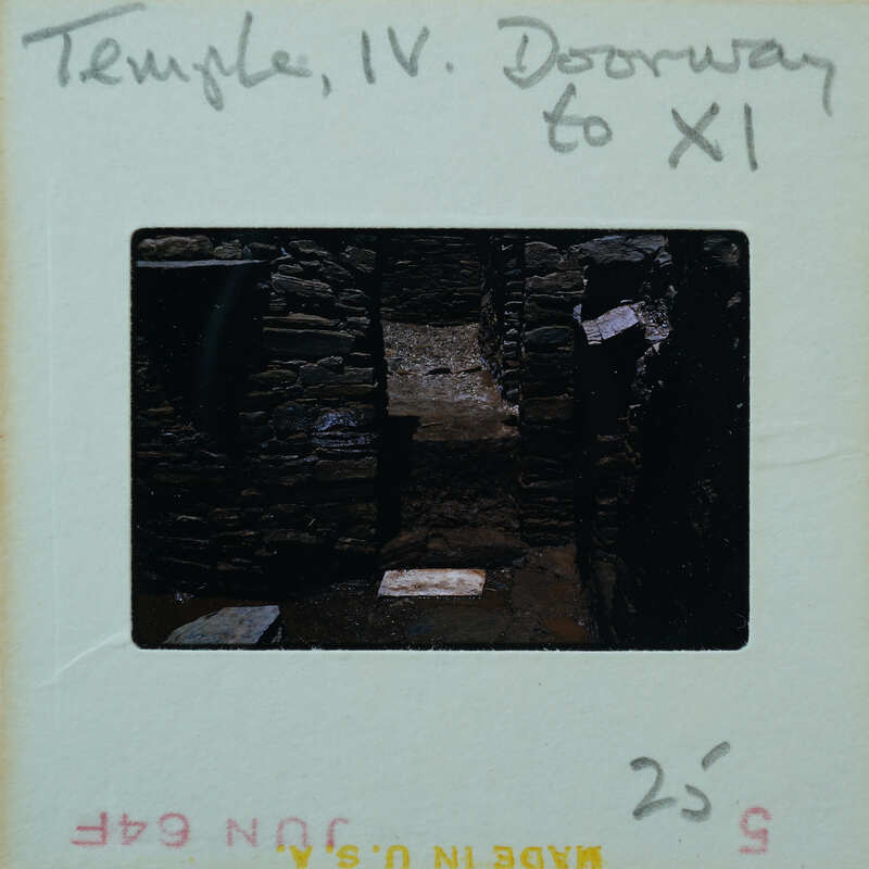 Marble step and doorway in muddy floor of building interior.