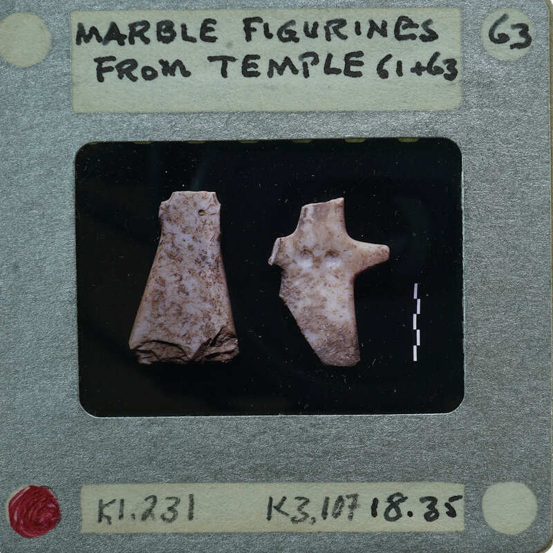 Two marble figurines displayed on a piece of paper.