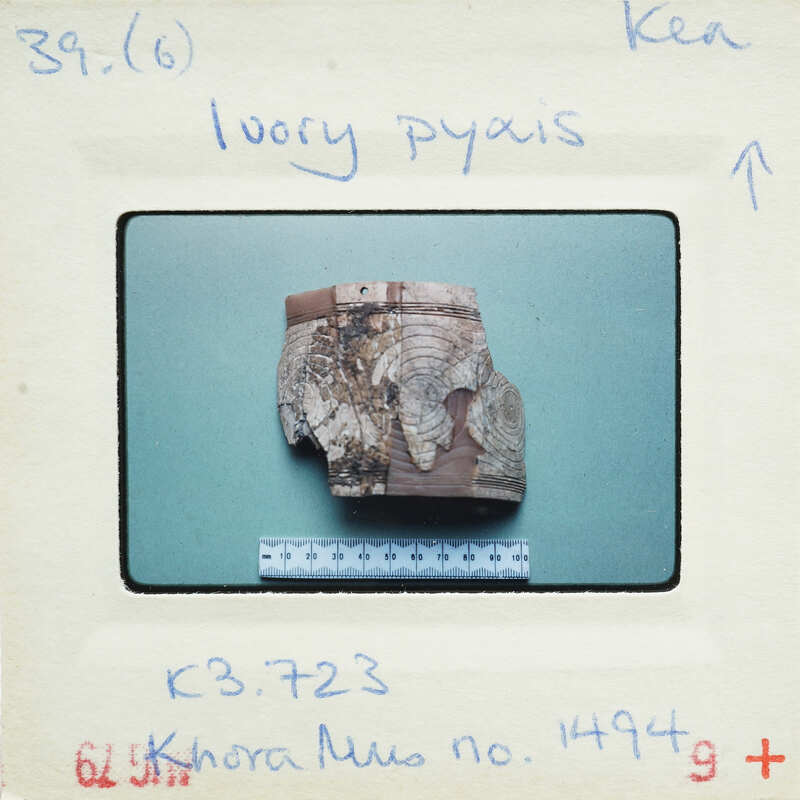 A small, damaged wooden object on a white background with measurements and labels.