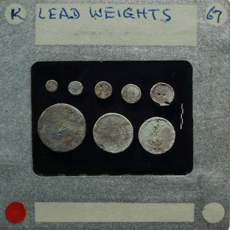 A collection of old coins displayed on a card with labels and weights.