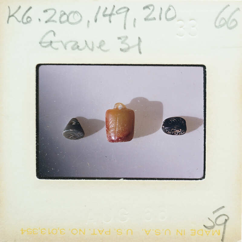 Three beads on a white surface with writing and numbers around them.