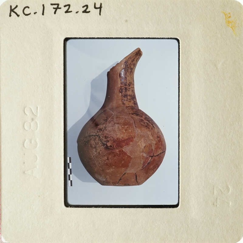 Old clay pot with cracks and worn surface, displayed on white background.