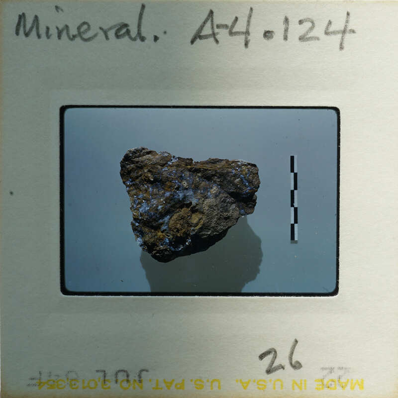 A photograph of a rock specimen on a label with handwritten notes.