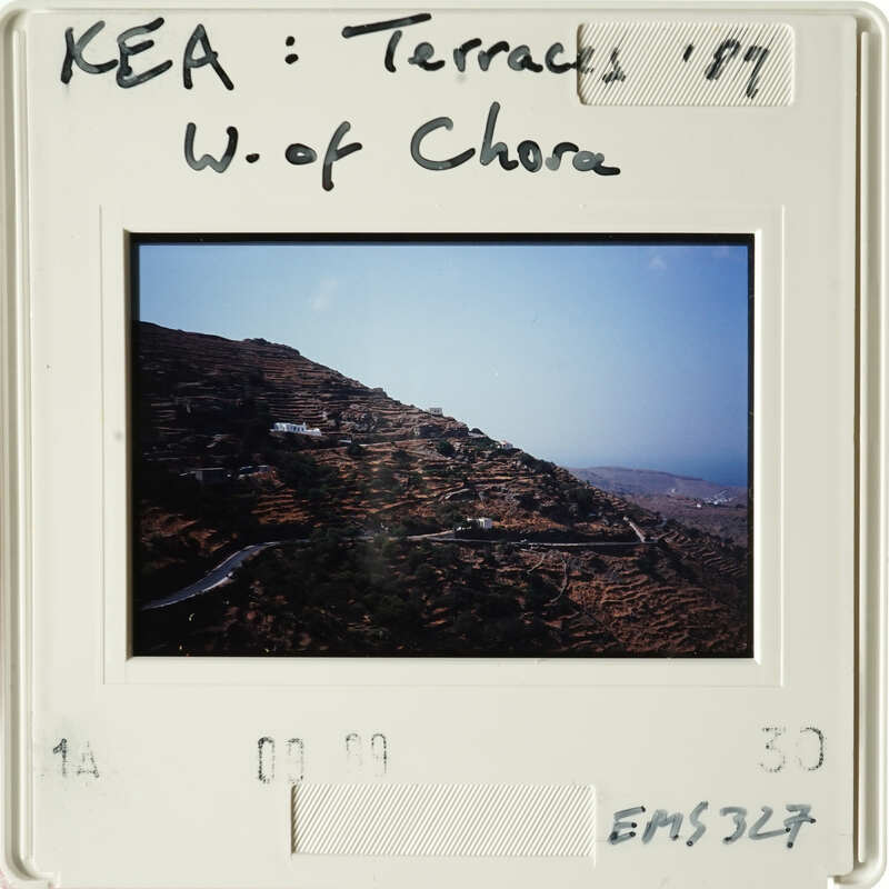 The photograph shows a scenic landscape with winding roads and hills, likely taken from an elevated vantage point.