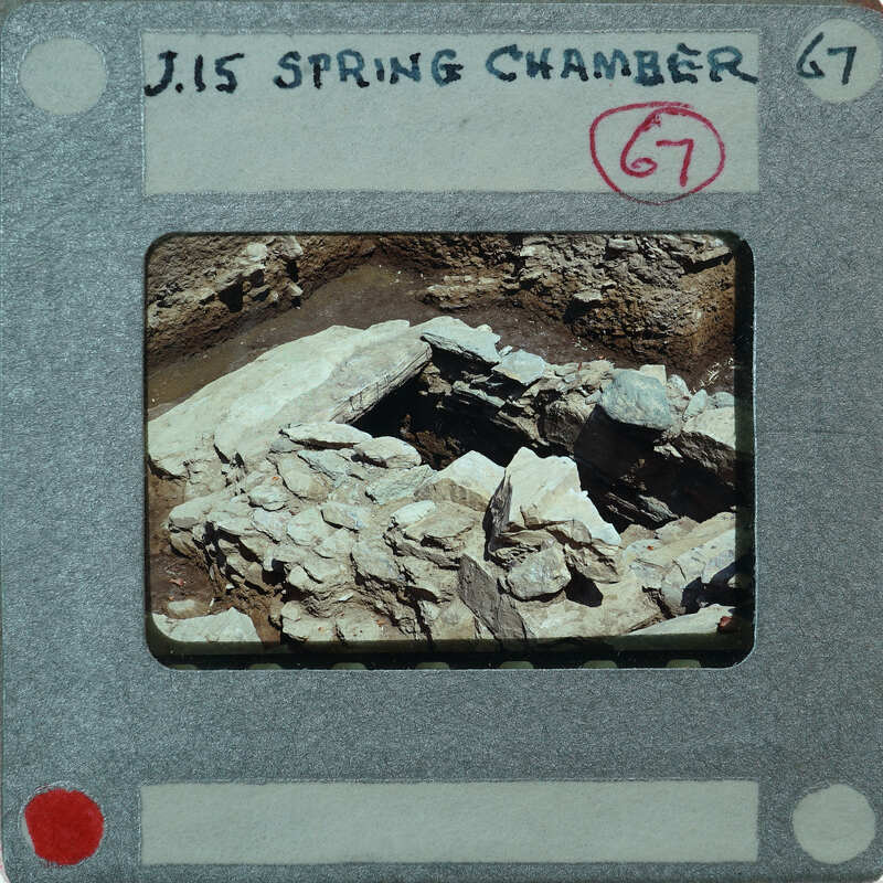 A photograph of a rock formation with a label indicating it's from the "J.15 Spring Chamber" and numbered 67.