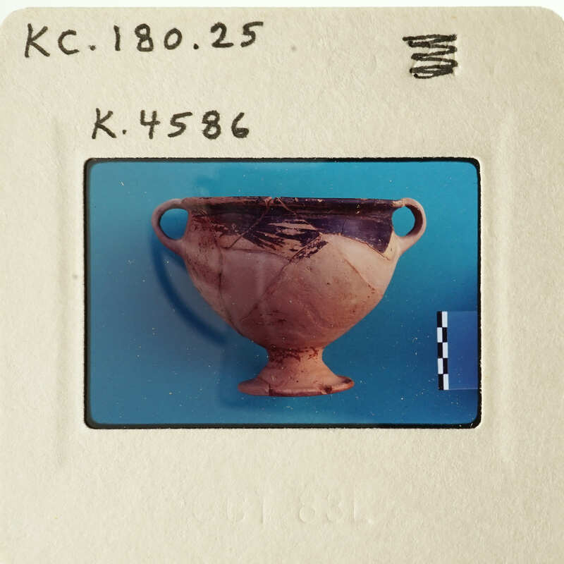 A photograph of an ancient Greek vase with a blue background.