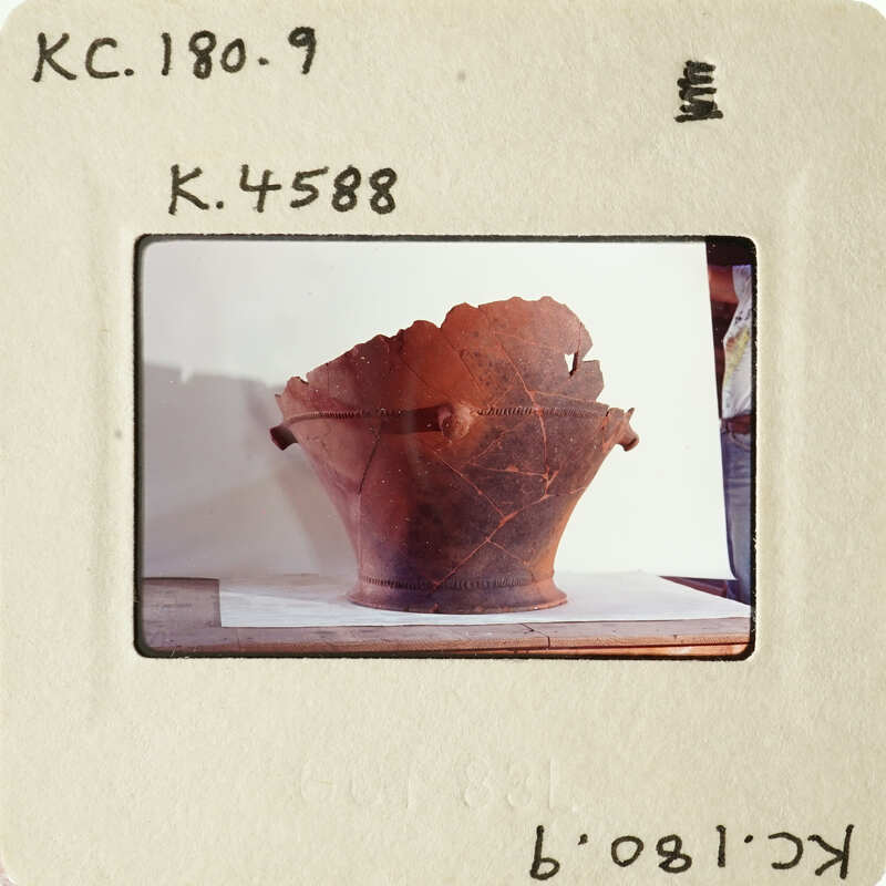 Ancient pottery on display with visible cracks and wear, photographed against a white background.