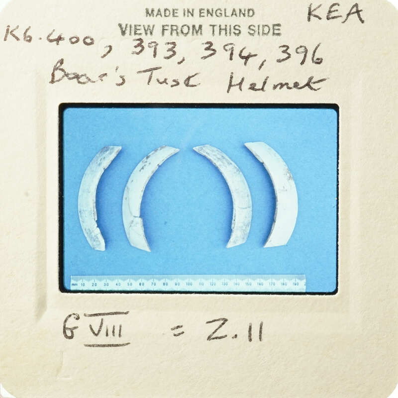 Old metal teeth with worn edges and a handwritten note on paper.