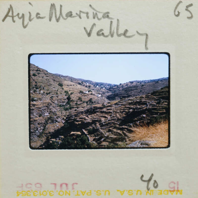 Photo of a rugged mountain landscape with dry vegetation and dirt roads.