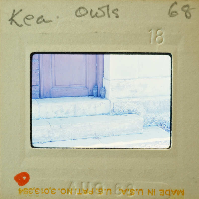 A vintage photograph of a doorway with steps, enclosed within an old film negative holder.