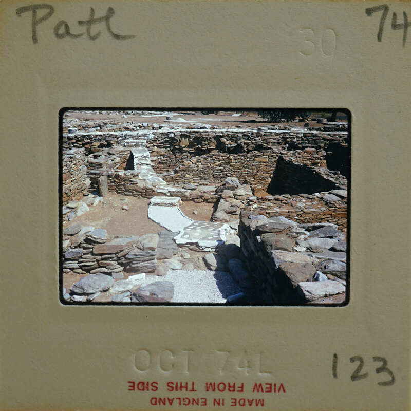 A photograph of an ancient stone structure with a dirt floor, possibly ruins.