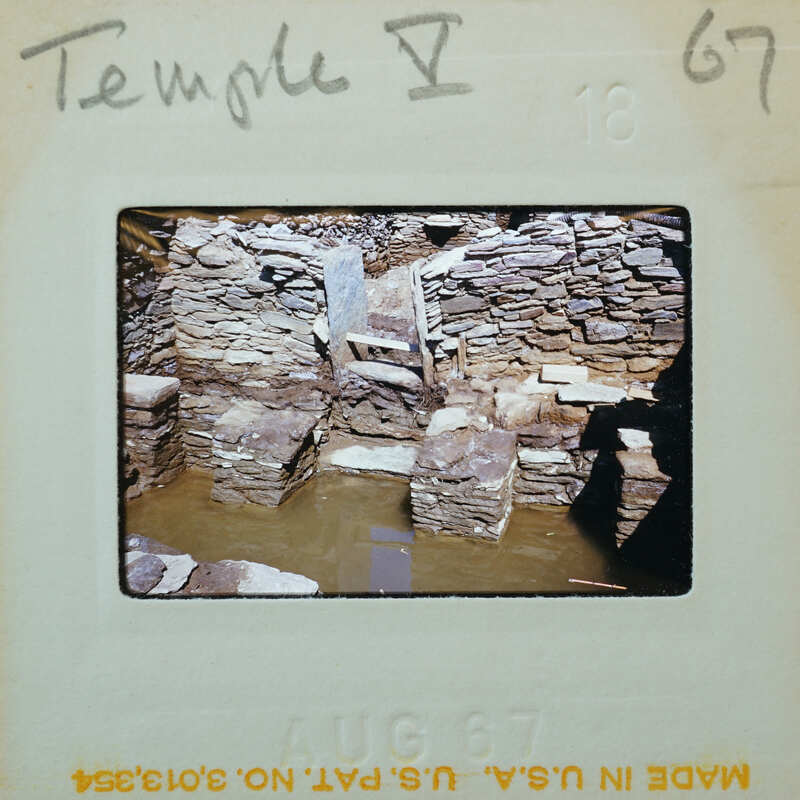 Stone ruins of a historical building with water around it.