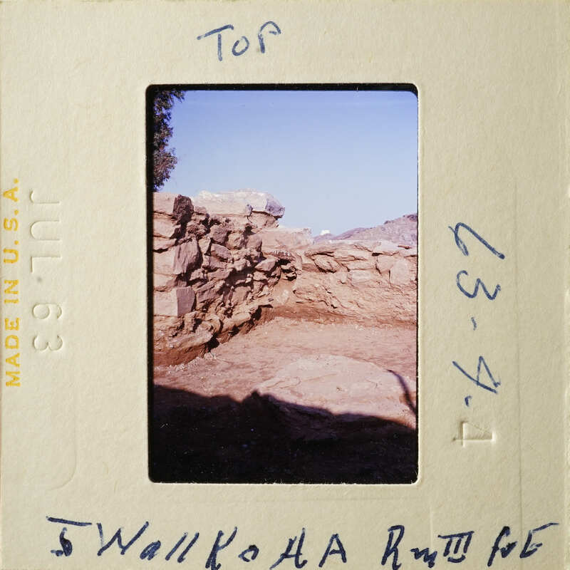 Stone ruins with vegetation and sky visible, on an old photographic film strip.