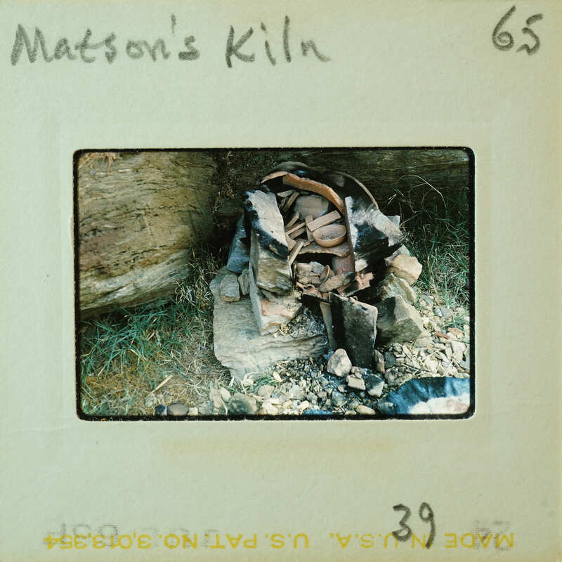 Old rusted metal objects piled on a rock surface.