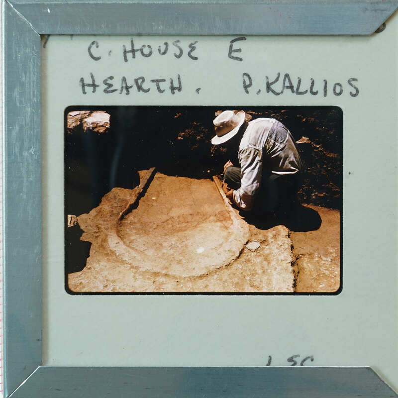 Man working on a large stone slab, possibly part of an archaeological excavation or historical site.