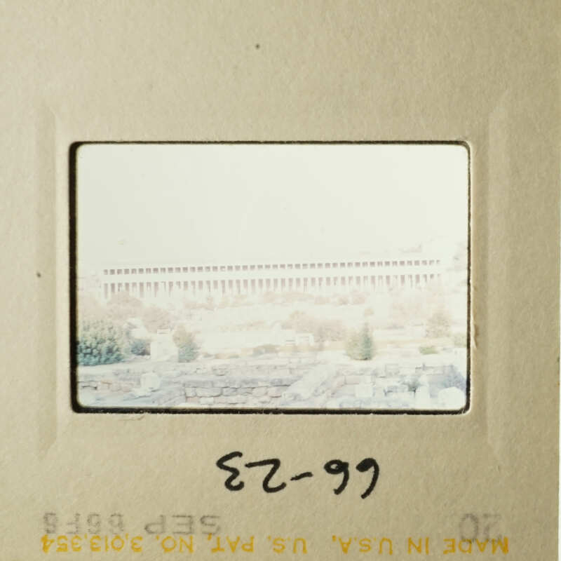 The photo shows an old-fashioned film strip with a view of a cityscape and a building, possibly a courthouse, in the background.