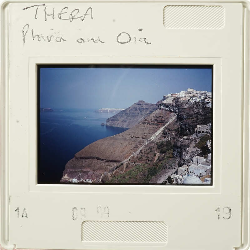 A photograph capturing an aerial view of a coastal landscape with cliffs and buildings, possibly taken from a plane window.