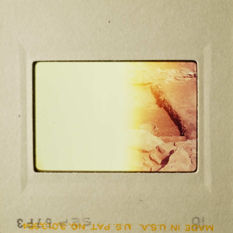 A faded photograph of a rocky landscape with a yellowish tint.