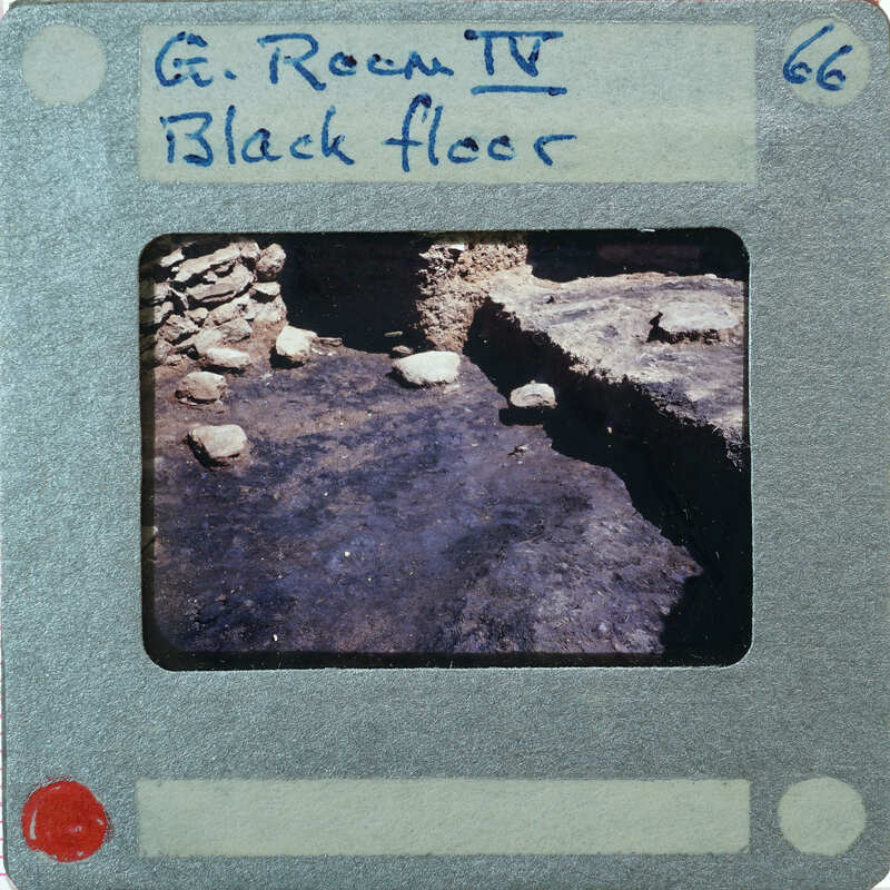 A black and white photograph of a stone floor with a handwritten label on the front.