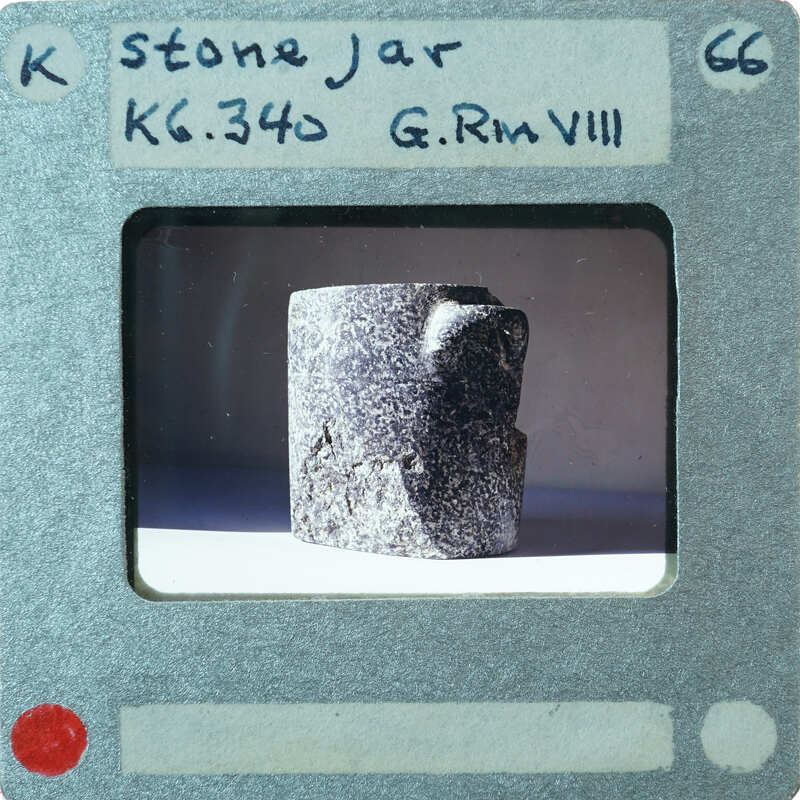 Upright stone vessel with handle in profile on table, K5.340.