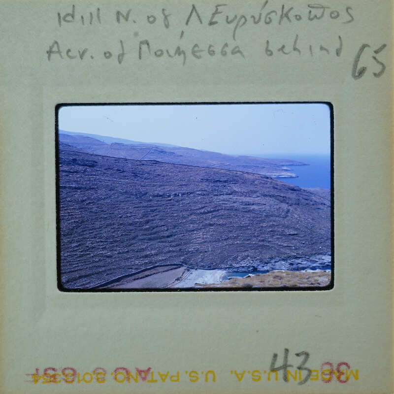 A photograph of a rugged coastline with mountains and the sea, on a vintage film strip.