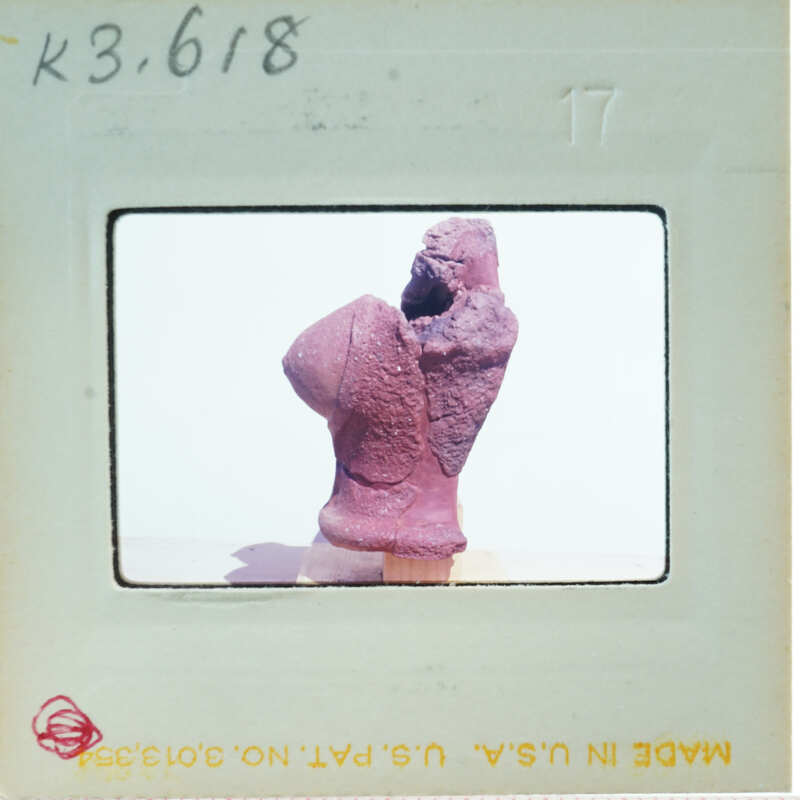 Terracotta figurine torso from side.