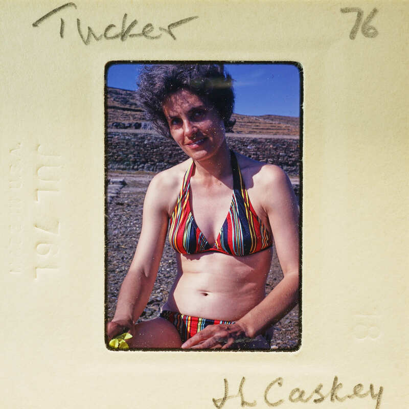 Woman wearing a colorful swimsuit in an old photo.