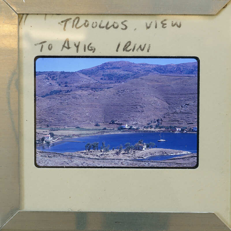 Picture of a scenic landscape with mountains, water, and houses.