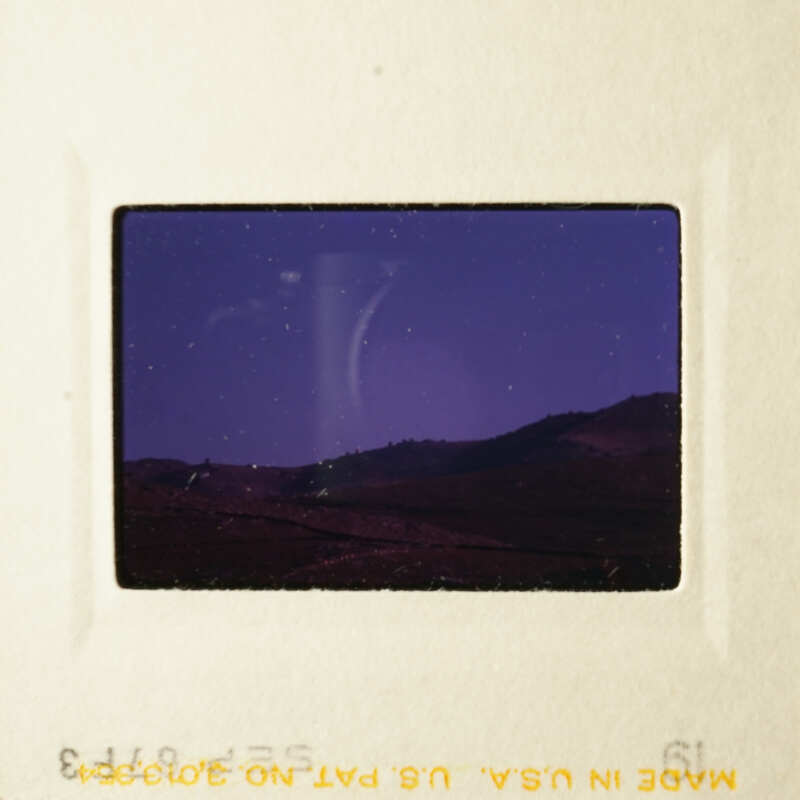 A nighttime scene with mountains and a starry sky captured on a slide.