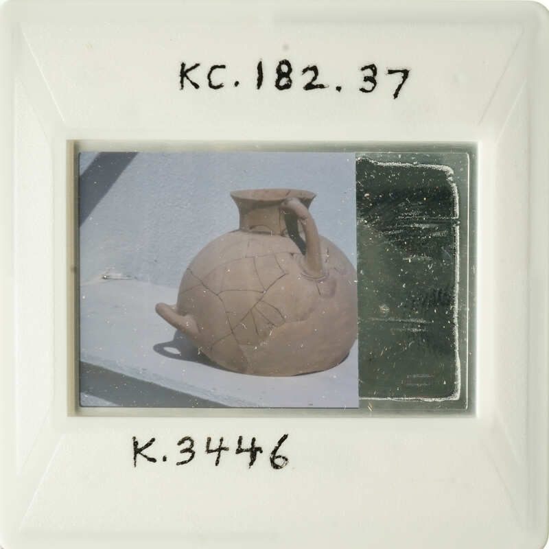 A photograph of an antique clay pot with visible cracks and imperfections.