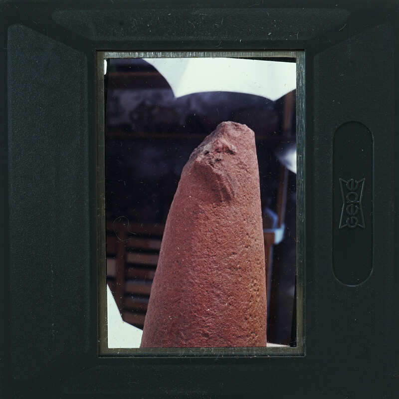 A close-up photo of a person holding an object with a face painted on it.