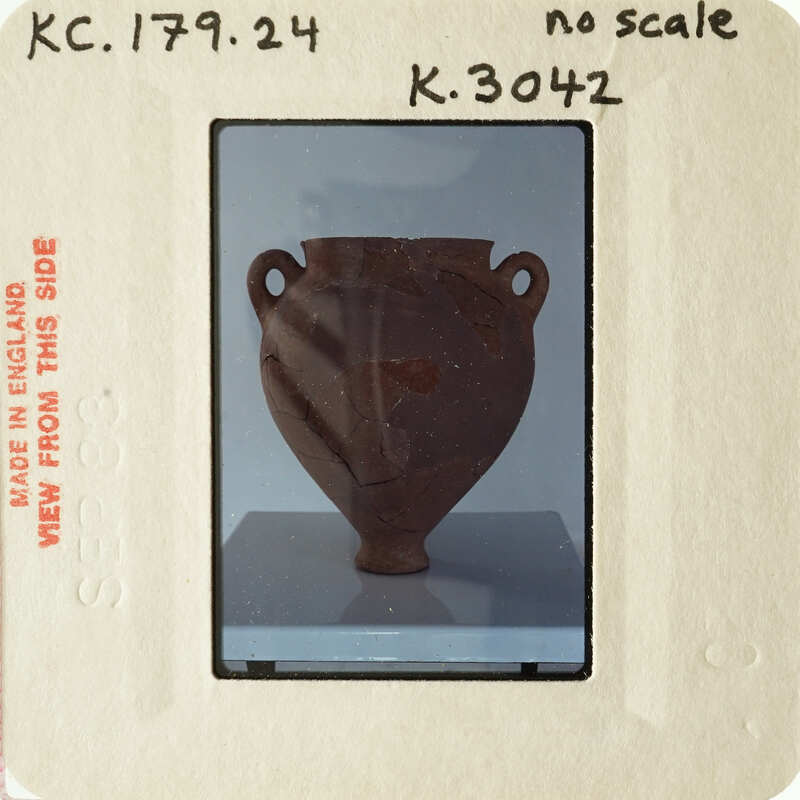 Ancient clay pot displayed on a pedestal.