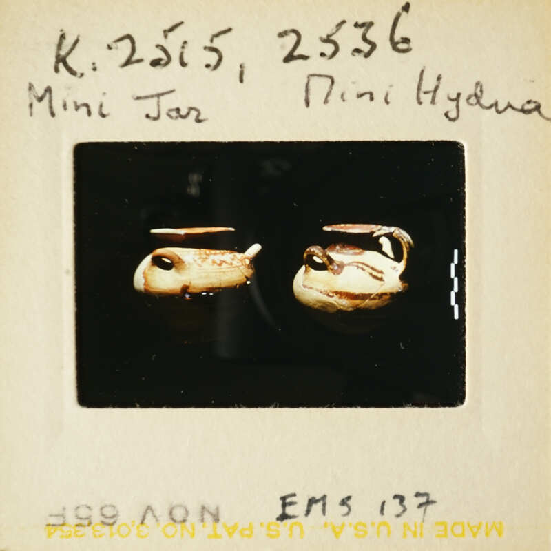 Two miniature jars with lids, displayed on a surface.