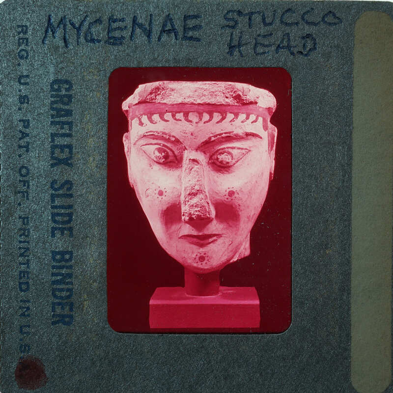 The image shows a vintage slide with an illustration of a Mycenaean head, possibly from an educational presentation or lecture.