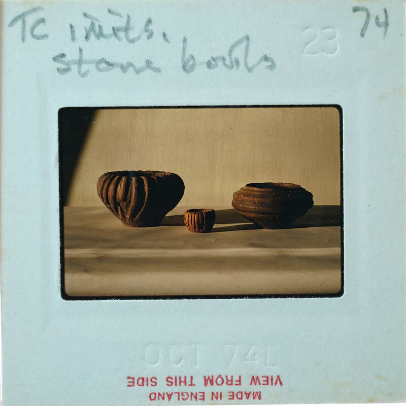 Three small bowls with various incised decorations in profile on a table.