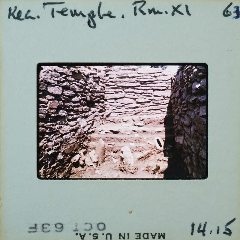 The image is a photograph of an old, dilapidated stone structure with visible ruins and debris.