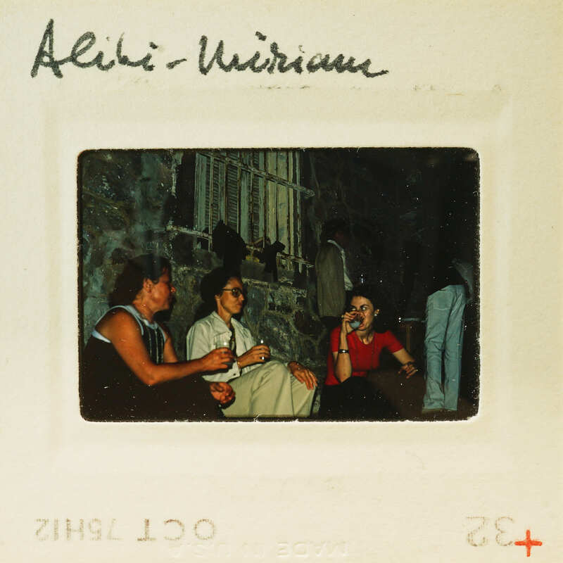 Old photograph of four people sitting together, possibly at a social event or gathering.