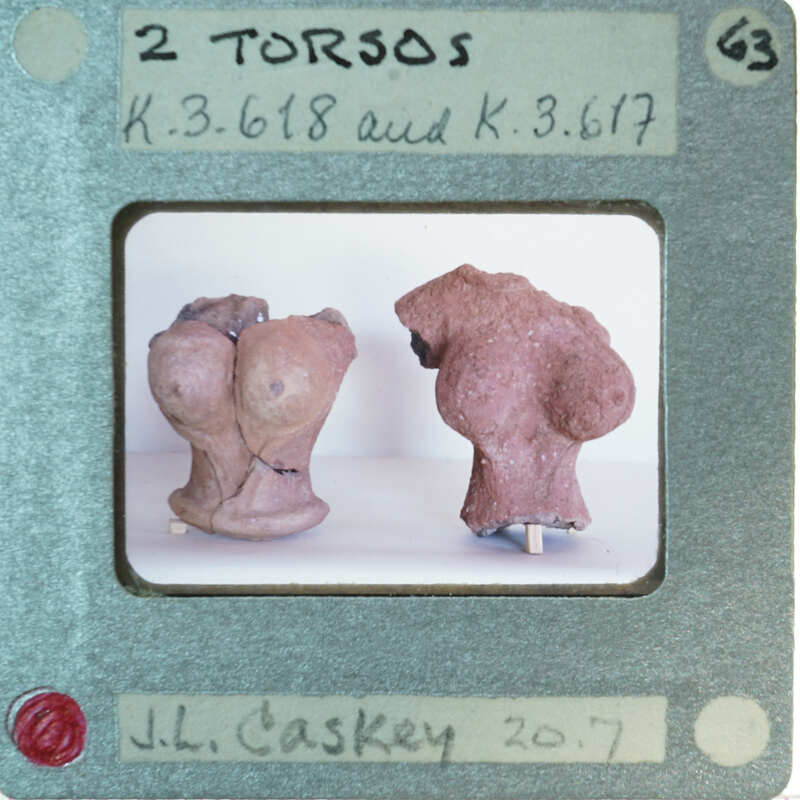 Two ancient clay figurines on display.