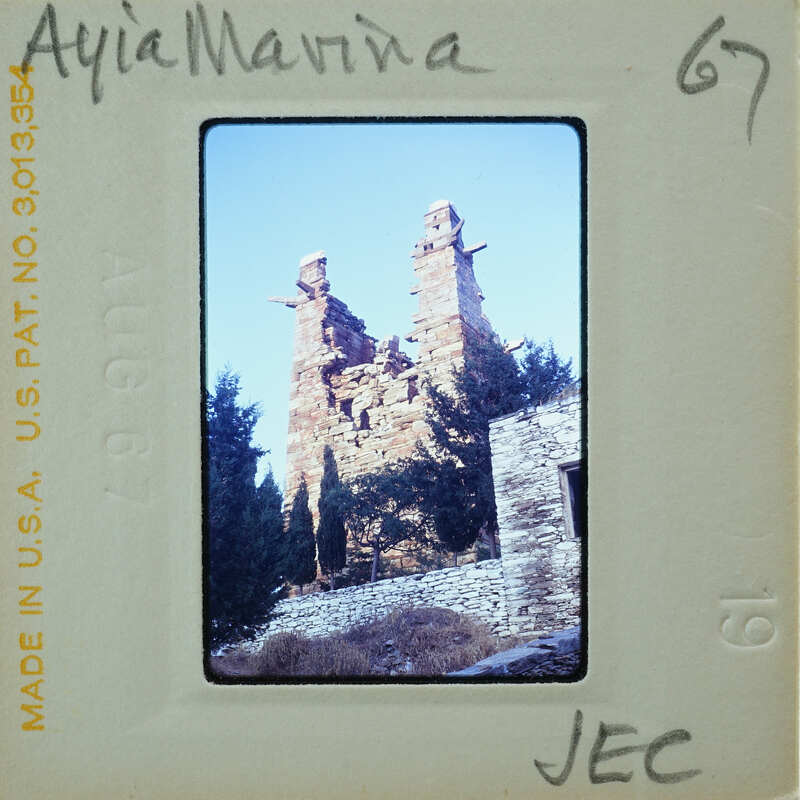 Old ruins of a stone structure with vegetation, captured on an analog film negative.
