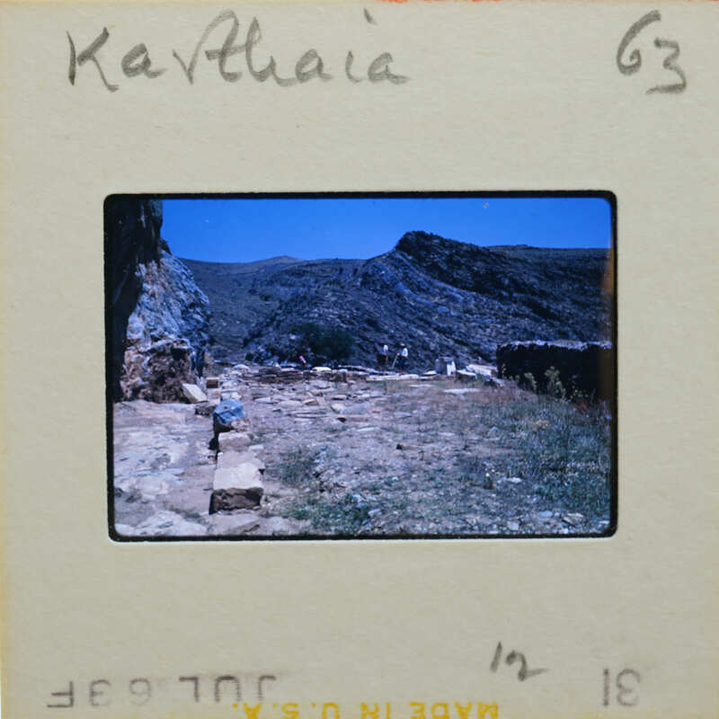 Slide of a mountainous landscape with ruins and a vintage film strip label.