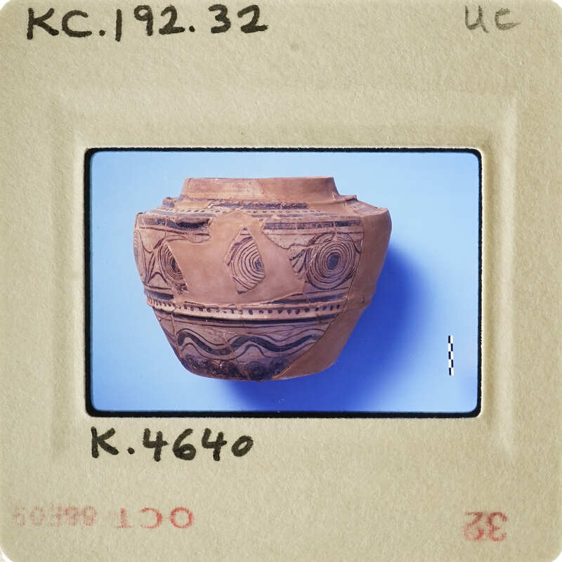 Ancient ceramic pot with intricate designs on display.