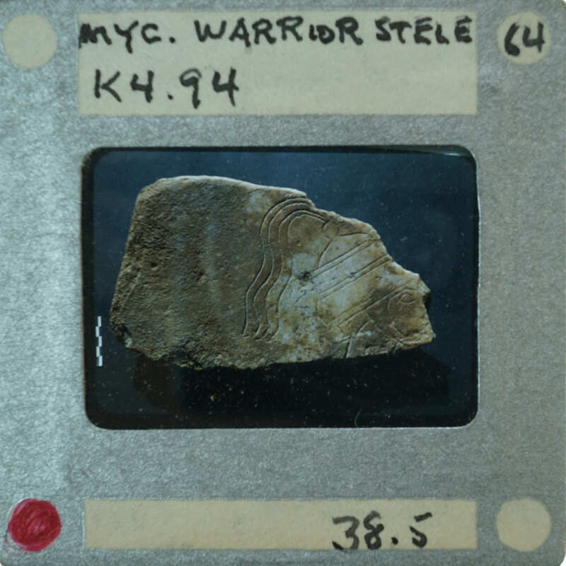 A small, ancient stone artifact with markings on display.