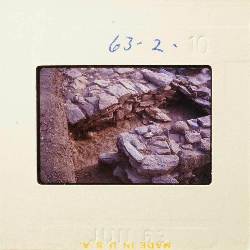 Old photograph of stone ruins with visible film strip and date stamp.